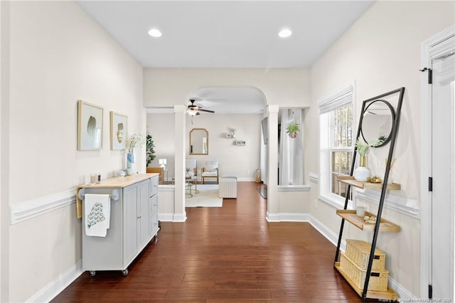 hallway with dark hardwood / wood-style flooring, radiator heating unit, and decorative columns