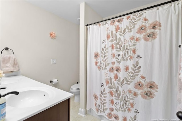 bathroom with tile patterned flooring, vanity, and toilet