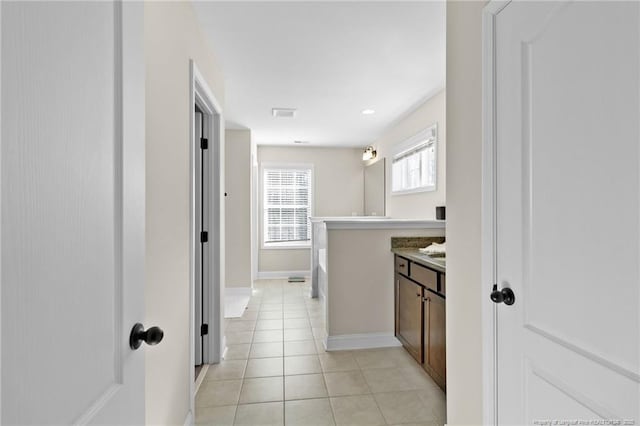 bathroom with vanity, a washtub, and tile patterned floors