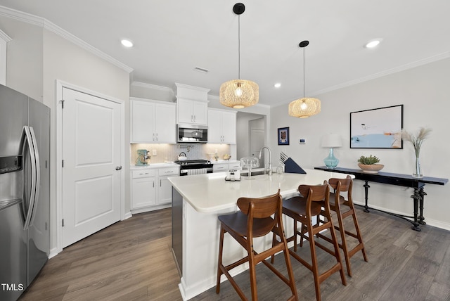 kitchen featuring a breakfast bar, decorative light fixtures, white cabinets, decorative backsplash, and stainless steel appliances