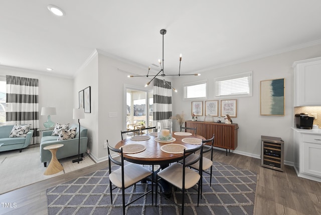 dining room featuring a notable chandelier, dark wood-type flooring, ornamental molding, and beverage cooler