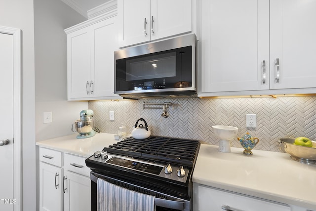 kitchen featuring white cabinetry, stainless steel appliances, crown molding, and backsplash