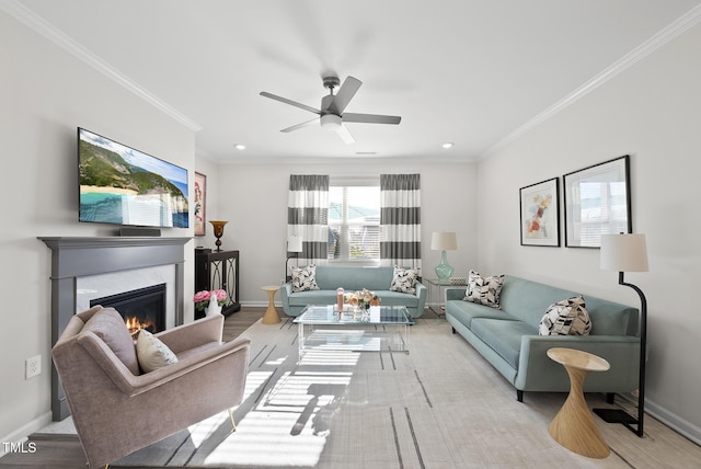 living room with light hardwood / wood-style flooring, crown molding, a fireplace, and ceiling fan