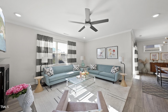 living room featuring crown molding, ceiling fan, and light wood-type flooring