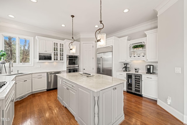 kitchen with wine cooler, appliances with stainless steel finishes, a center island, and sink