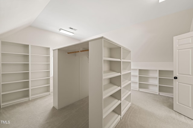 spacious closet with vaulted ceiling and light carpet