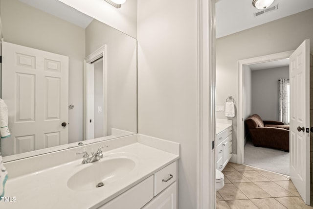 bathroom with tile patterned flooring, vanity, and toilet