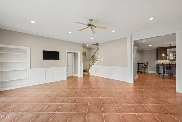 unfurnished living room featuring light tile patterned flooring, ornamental molding, and ceiling fan