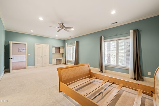 bedroom featuring multiple windows, crown molding, and light carpet