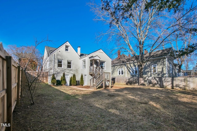 rear view of house featuring a lawn