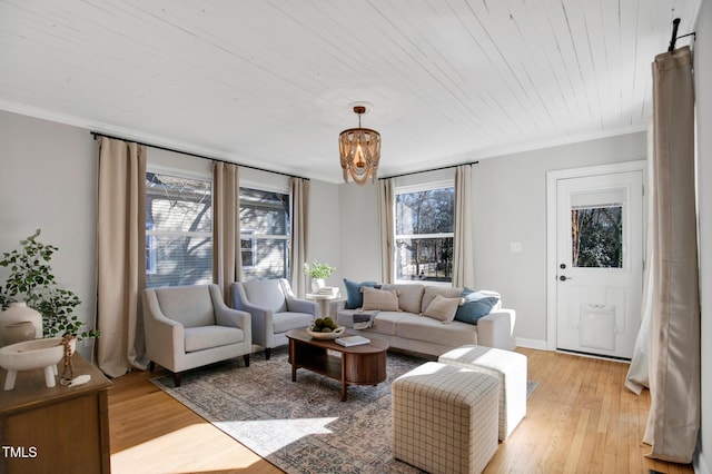 living room with ornamental molding, wood ceiling, and light hardwood / wood-style floors