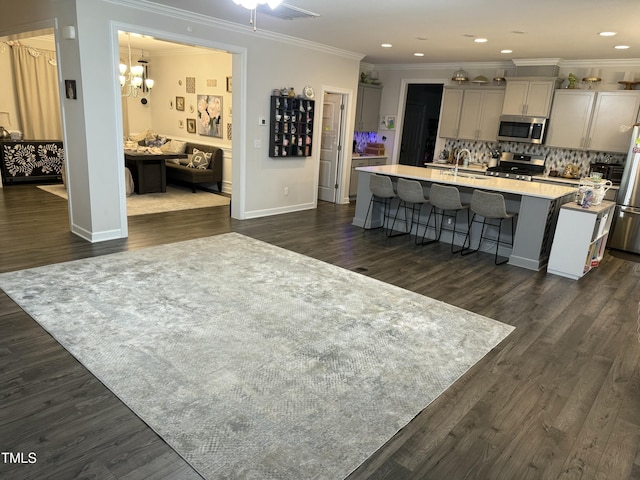 kitchen featuring gray cabinetry, light countertops, a kitchen island with sink, and stainless steel appliances