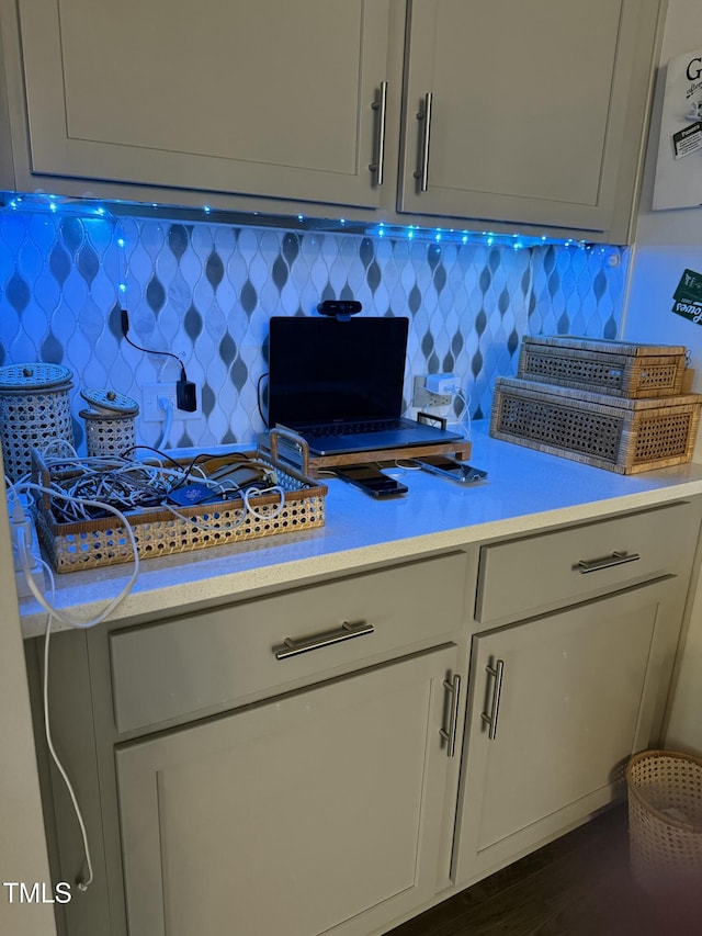 kitchen with tasteful backsplash, light countertops, and dark wood-type flooring