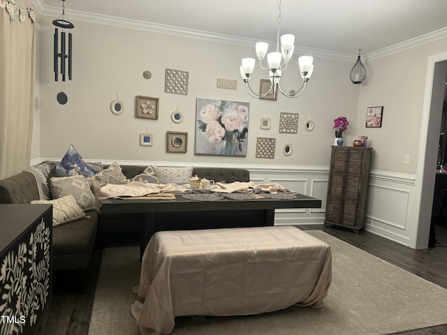 bedroom featuring a wainscoted wall, a decorative wall, dark wood finished floors, and crown molding