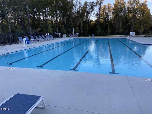 community pool featuring fence and a patio