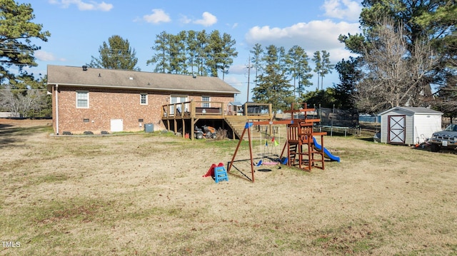 view of playground featuring a trampoline, a lawn, a deck, and a shed