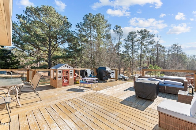 wooden deck with grilling area and an outdoor living space