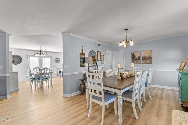 dining room with an inviting chandelier, crown molding, visible vents, and light wood finished floors