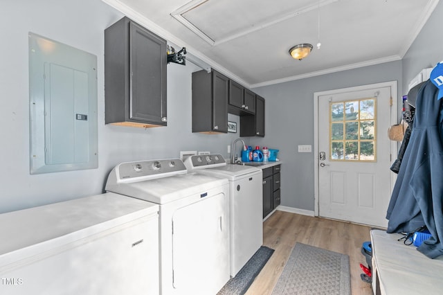 washroom with crown molding, washing machine and dryer, electric panel, cabinet space, and a sink