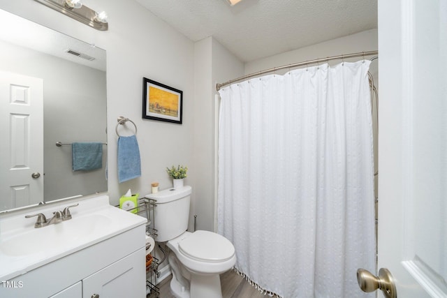 bathroom with vanity, a textured ceiling, and toilet