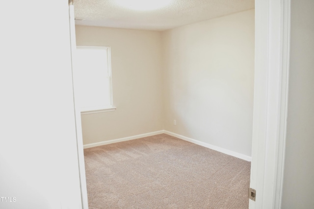 carpeted empty room with a textured ceiling