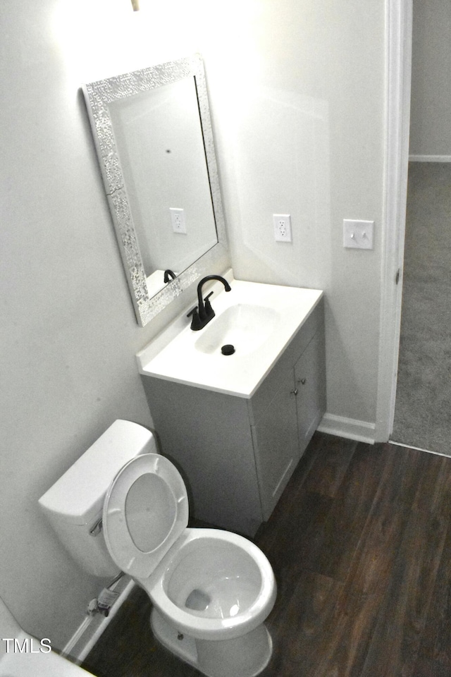 bathroom with vanity, toilet, and hardwood / wood-style floors