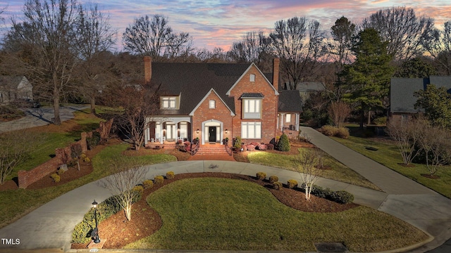 2035 Stuart Ct, Burlington, NC 27215 - traditional-style home with a chimney, curved driveway, a front lawn, and brick siding