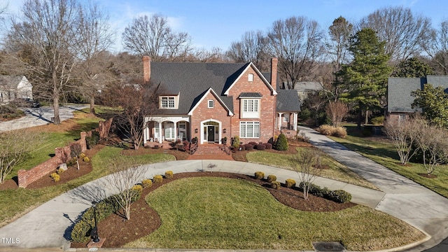 2035 Stuart Ct, Burlington, NC 27215 - view of front of property featuring curved driveway, a chimney, a front yard, and brick siding
