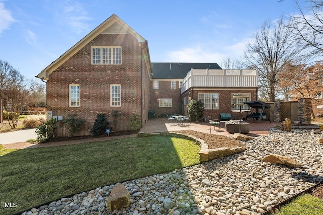 2035 Stuart Ct, Burlington, NC 27215 - back of house featuring brick siding, a patio, a lawn, and an outdoor fire pit