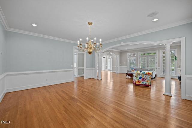 2035 Stuart Ct, Burlington, NC 27215 - dining area featuring arched walkways, a chandelier, light wood-style flooring, crown molding, and a wainscoted wall