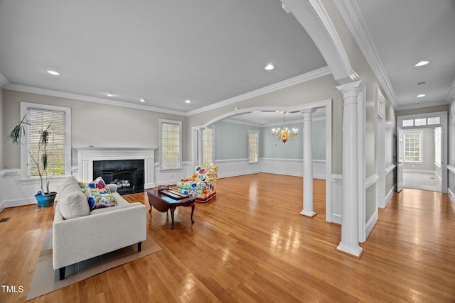 2035 Stuart Ct, Burlington, NC 27215 - living area with a fireplace with flush hearth, light wood finished floors, decorative columns, wainscoting, and arched walkways