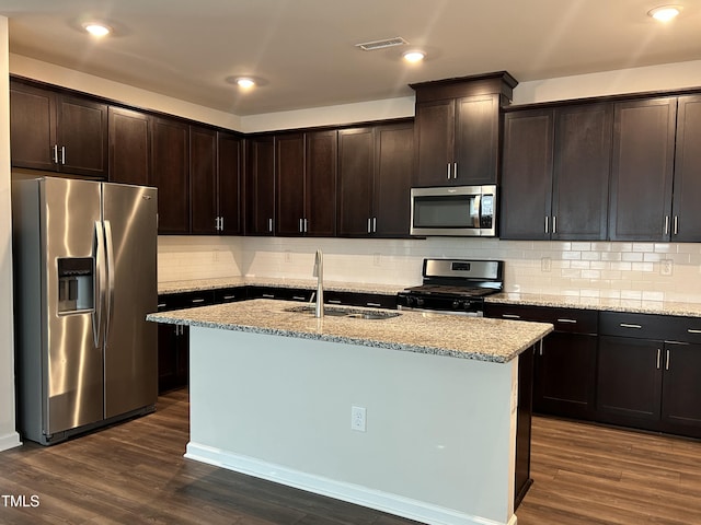 kitchen featuring an island with sink, appliances with stainless steel finishes, sink, and dark brown cabinets