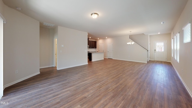 unfurnished living room featuring dark hardwood / wood-style floors and a chandelier