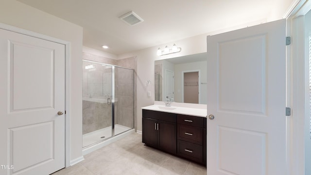 bathroom featuring vanity, an enclosed shower, and tile patterned flooring