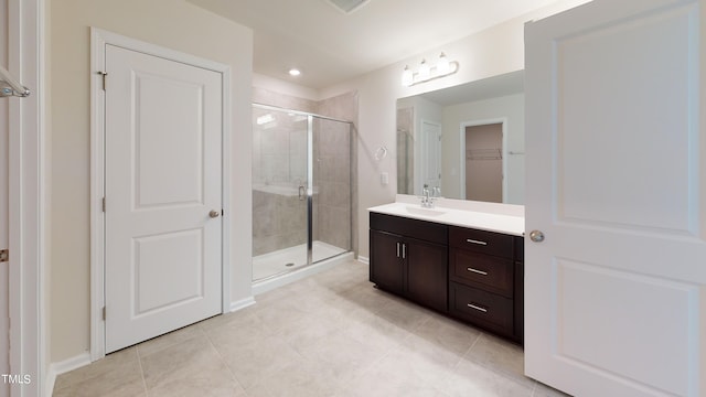 bathroom with tile patterned floors, vanity, and a shower with door