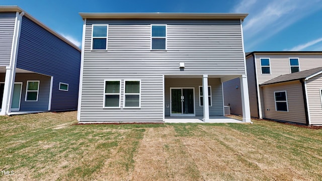 rear view of house with a patio and a lawn