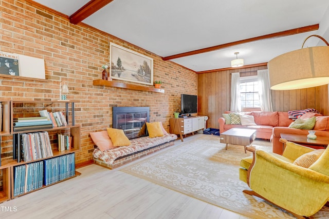 living room with beam ceiling, wood walls, hardwood / wood-style flooring, brick wall, and a fireplace