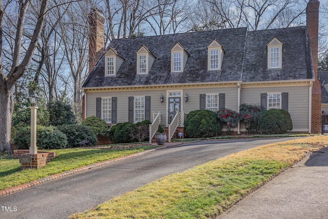 cape cod-style house featuring a front yard