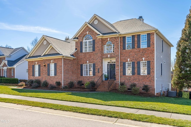 view of front of house featuring a front lawn and central air condition unit