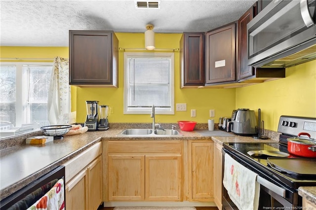 kitchen with appliances with stainless steel finishes, sink, and a textured ceiling