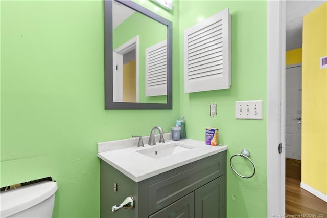 bathroom featuring hardwood / wood-style flooring, vanity, and toilet