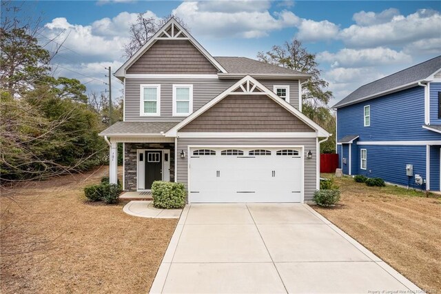 craftsman house featuring a garage and a front lawn