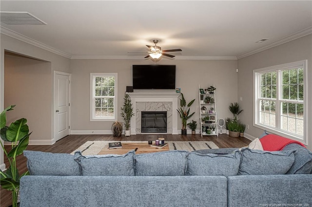 living room featuring a premium fireplace, crown molding, ceiling fan, and dark hardwood / wood-style flooring