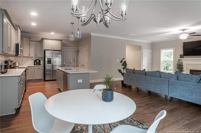 dining room with crown molding, sink, dark wood-type flooring, and ceiling fan