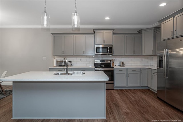 kitchen featuring gray cabinets, dark hardwood / wood-style floors, pendant lighting, a kitchen island with sink, and stainless steel appliances