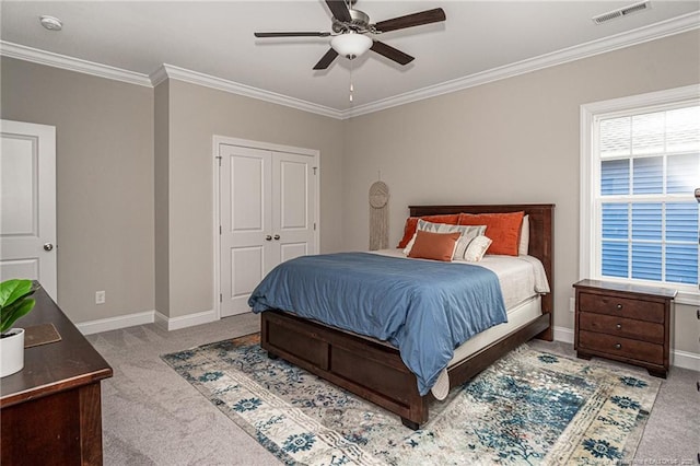 carpeted bedroom featuring crown molding, ceiling fan, and a closet