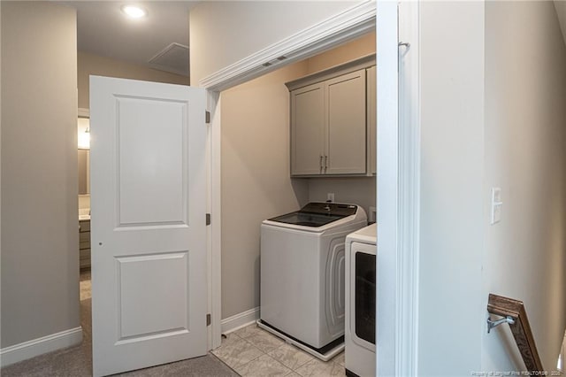 clothes washing area with cabinets and separate washer and dryer