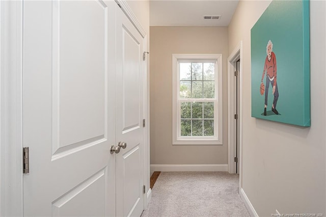 corridor with plenty of natural light and light carpet