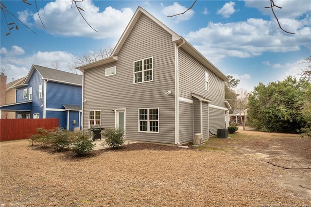 rear view of house with cooling unit, a yard, and a patio