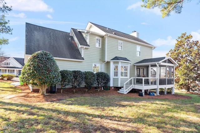 back of property featuring a sunroom and a lawn